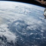 Spacecraft orbiting above Earth blue atmospheric limb